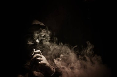 Bir mod tutarak Vaping adam. Buhar bulutu. Siyah arka plan. Vaping çok duman ile elektronik sigara