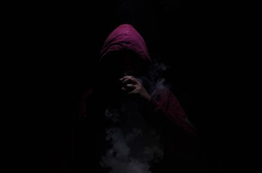 Bir mod tutarak Vaping adam. Buhar bulutu. Siyah arka plan. Vaping çok duman ile elektronik sigara