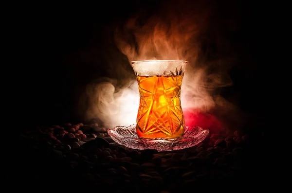 Turecké Ázerbájdžán čaj v tradiční glasse a hrnec na černém pozadí se světly a kouř. Tradiční pohár armudu — Stock fotografie