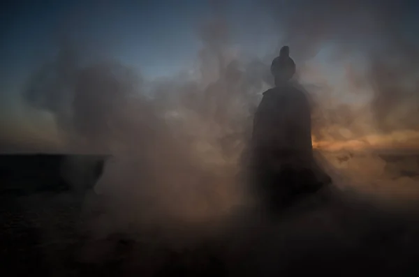 A silhueta do homem árabe está sozinha no deserto e observando o pôr-do-sol com nuvens de nevoeiro. Conto de fadas oriental — Fotografia de Stock
