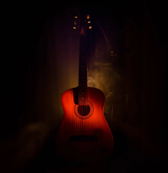 Conceito musical. Guitarra acústica isolada em fundo escuro sob feixe de luz com fumaça com espaço de cópia. Cordas de guitarra, de perto. Foco seletivo. Efeitos de fogo — Fotografia de Stock