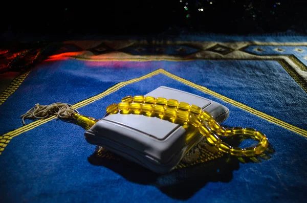 Sagrado Corán con cuentas en una alfombra de oración, Muslim Tasbih es una cadena de cuentas de oración que tradicionalmente utilizan los musulmanes junto con el Corán. Concepto de vacaciones Ramadán — Foto de Stock