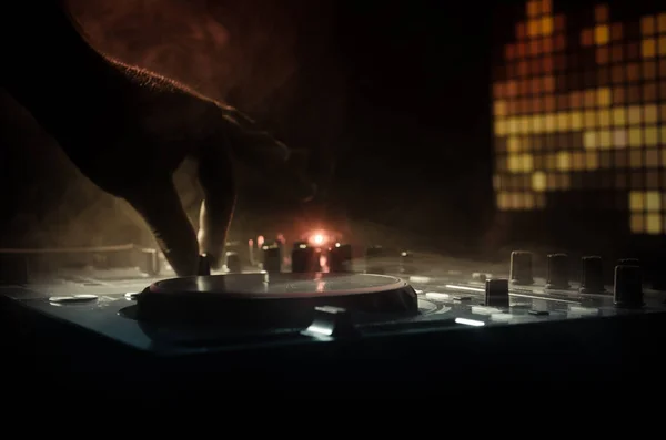 DJ Spinning, blandande och skrapa på en nattklubb, händerna på dj tweak olika spår kontrollerna på dj: s däck, strobe ljus och dimma, selektivt fokus — Stockfoto