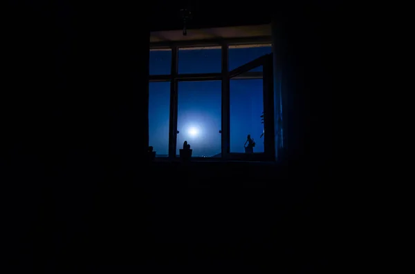 Escena nocturna de luna vista a través de la ventana desde el cuarto oscuro. —  Fotos de Stock