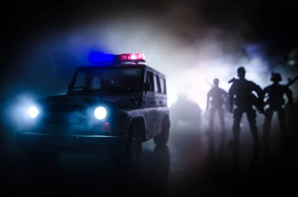 Bereitschaftspolizisten signalisieren Bereitschaft. Machtkonzept der Regierung. Polizei im Einsatz. Rauch auf dunklem Hintergrund mit Lichtern. Blaurote blinkende Sirenen. Macht der Diktatur. — Stockfoto