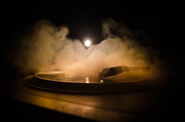Pikap vinil plak çalar. Retro ses ekipmanları için disk jokey. Dj mix ve müzik çalmak için ses teknolojisi. Yangın arka plan duman ile yanan karşı oynanan vinil kaydı. Vintage