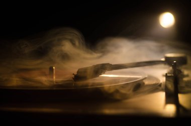 Pikap vinil plak çalar. Retro ses ekipmanları için disk jokey. Dj mix ve müzik çalmak için ses teknolojisi. Yangın arka plan duman ile yanan karşı oynanan vinil kaydı. Vintage