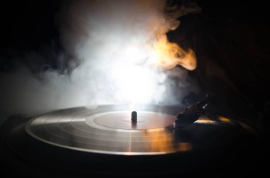 Pikap vinil plak çalar. Retro ses ekipmanları için disk jokey. Dj mix ve müzik çalmak için ses teknolojisi. Yangın arka plan duman ile yanan karşı oynanan vinil kaydı. Vintage