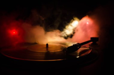Pikap vinil plak çalar. Retro ses ekipmanları için disk jokey. Dj mix ve müzik çalmak için ses teknolojisi. Yangın arka plan duman ile yanan karşı oynanan vinil kaydı. Vintage