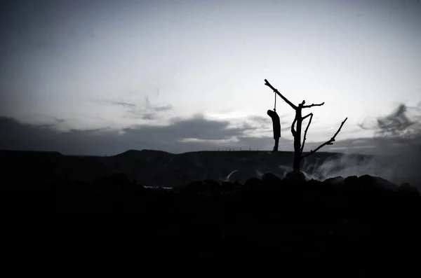 Horror view of hanged girl on tree at evening (at night) Suicide decoration. Death punishment executions or suicide abstract idea.