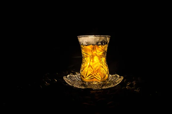 Türkischer Azerbaijan-Tee in traditionellem Glas und Kanne auf schwarzem Hintergrund mit Licht und Rauch. Armudu-Pokal — Stockfoto