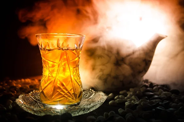Турецкий азербайджанский чай в традиционном стекле и горшок на черном фоне с огнями и дымом. Армуду — стоковое фото