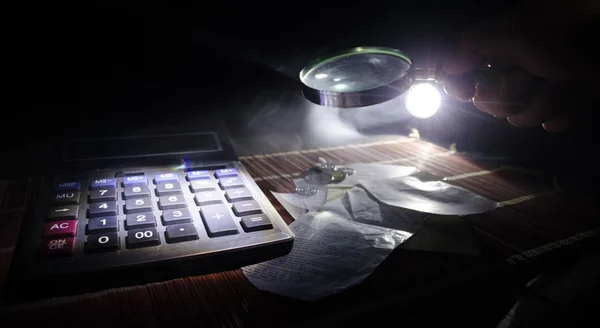 Acessórios de negócios (lupa, calculadora) e gráficos, tabelas, gráficos em uma mesa com fundo escuro. Foco seletivo — Fotografia de Stock