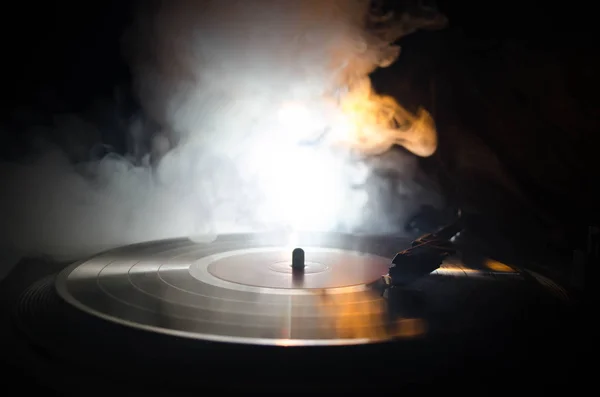 Tocador de vinilo giratorio. Equipo de audio retro para disc jockey. Tecnología de sonido para DJ para mezclar y reproducir música. Grabación de vinilo que se reproduce contra el fuego ardiente de fondo con humo. Vintage —  Fotos de Stock