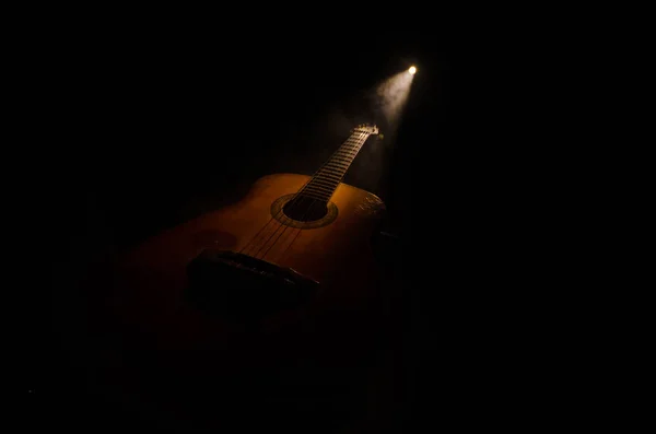 Μουσική αντίληψη. Ακουστική κιθάρα που απομονώνονται σε ένα σκοτεινό φόντο κάτω από την ακτίνα του φωτός με τον καπνό με αντίγραφο χώρο. Χορδές κιθάρας, κοντινό πλάνο. Επιλεκτική εστίαση. Εφέ φωτιά — Φωτογραφία Αρχείου