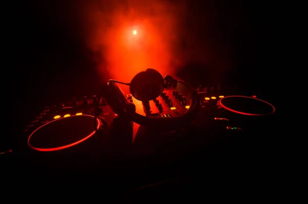 DJ Spinning, Mixing, and Scratching in a Night Club, Hands of dj tweak various track controls on dj's deck, strobe lights and fog, selective focus — Stock Photo, Image