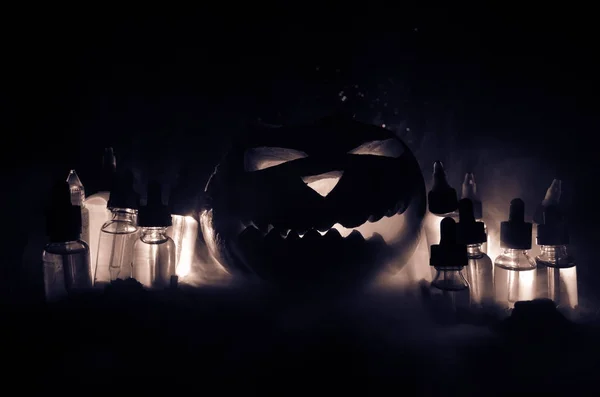 Kleurrijke vape vloeistoffen met Halloween Pumpkin op donkere achtergrond. Vape concept — Stockfoto
