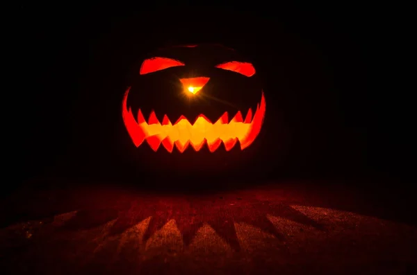 Halloween - old jack-o-lantern on black background. Spooky Halloween background with pumpkin — Stock Photo, Image