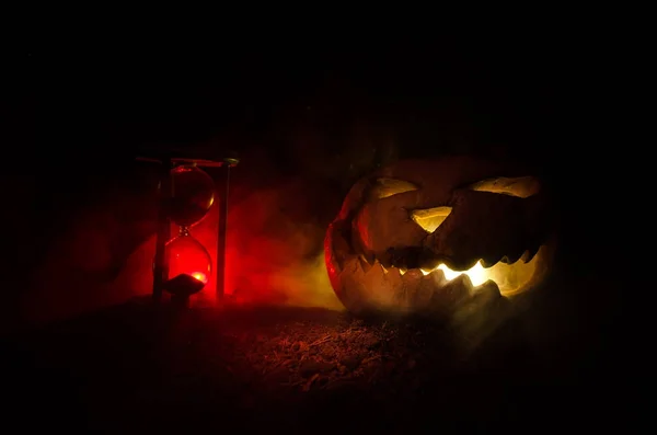 Reloj de arena. Halloween cabeza de calabaza Jack linterna con caras malvadas miedo vacaciones espeluznantes con velas encendidas sobre fondo de madera. Halloween vacaciones diseño de arte, celebración . — Foto de Stock