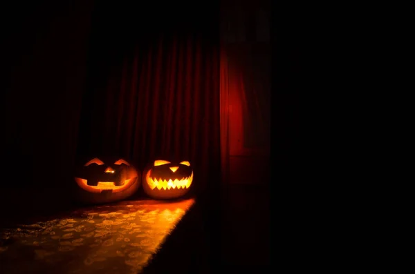 Calabaza de Halloween miedo en la ventana de la casa mística por la noche o calabaza de Halloween en la noche en la habitación con ventana azul. Símbolo de halloween en ventana . — Foto de Stock