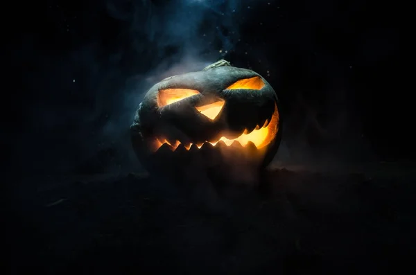 Halloween-Kürbisse lächeln und kratzen die Augen für die Partynacht. Nahaufnahme von gruseligen Halloween-Kürbissen mit innen leuchtenden Augen vor schwarzem Hintergrund — Stockfoto
