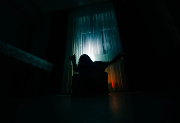Жахлива жінка в дереві вікна рука тримає клітку страшної сцени Хеллоуїн концепції Розмитий силует відьми. Вибірковий фокус — стокове фото