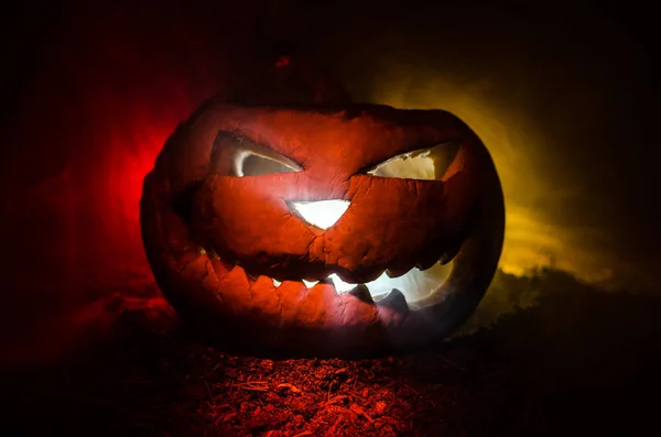 Calabazas de Halloween sonrisa y ojos rasgados para la noche de fiesta. Vista de cerca de la aterradora calabaza de Halloween con los ojos brillando en el interior en el fondo negro — Foto de Stock