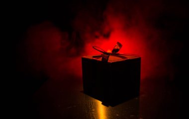 koyu tonlu arka plan üzerinde kırmızı fiyonklu kırmızı hediye kutusu