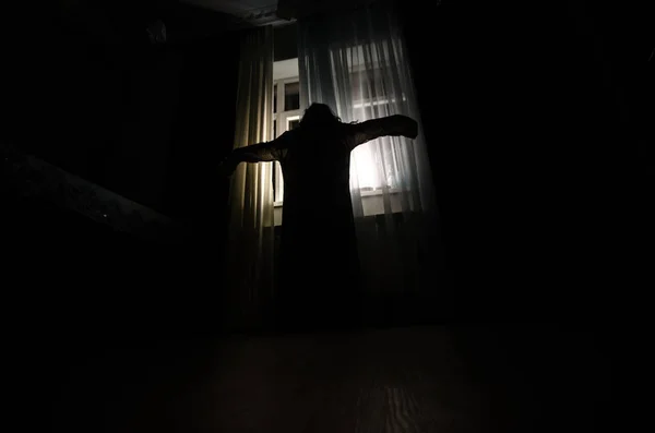 Φρίκη γυναίκα στο παράθυρο ξύλου χέρι κρατήστε κλουβί τρομακτική σκηνή Απόκριες έννοια θολωμένη σιλουέτα της μάγισσας. Επιλεκτική εστίαση — Φωτογραφία Αρχείου