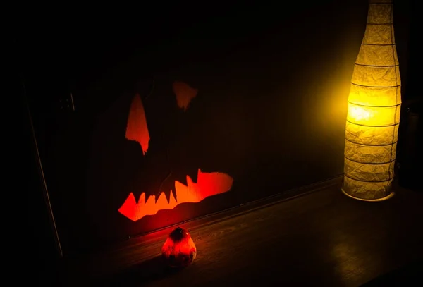 Halloween - szörnyű tök fekete háttér. Halloween ragyogó sütőtök határ levelek fölött meleg fa háttér, őszi szünet, hagyományos party dekoráció — Stock Fotó