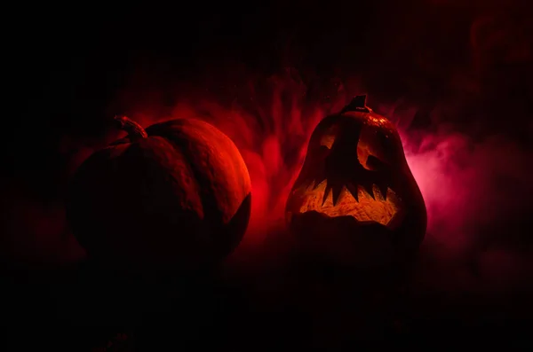 Halloween-Kürbisse lächeln und kratzen die Augen für die Partynacht. Nahaufnahme von gruseligen Halloween-Kürbissen mit innen leuchtenden Augen vor schwarzem Hintergrund — Stockfoto
