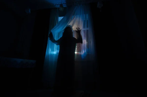 Horror-Frau in Fensterholz Hand halten Käfig gruselige Szene Halloween-Konzept verschwommene Silhouette der Hexe. Selektiver Fokus — Stockfoto
