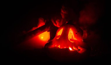 Korkunç turuncu kabak oyma gözleri ve yanan mumlar ve bir balta yangın gökyüzü karanlık bir zemin üzerine ile bir gülümseme ile. Cadılar Bayramı partisi için. Boş alan.