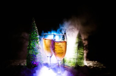 Flüt çifti ve şişe şampanya ile kar koyu arka plan üzerinde Noel ağacına yılbaşı kutlama arka plan.