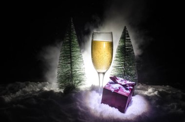 Flüt çifti ve şişe şampanya ile kar koyu arka plan üzerinde Noel ağacına yılbaşı kutlama arka plan.