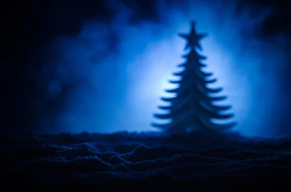 Рождественский фон со снежными елками. Снежная крытая елка ярко выделяется на фоне темно-синих оттенков этой заснеженной сцены. Тонкий темный фон — стоковое фото