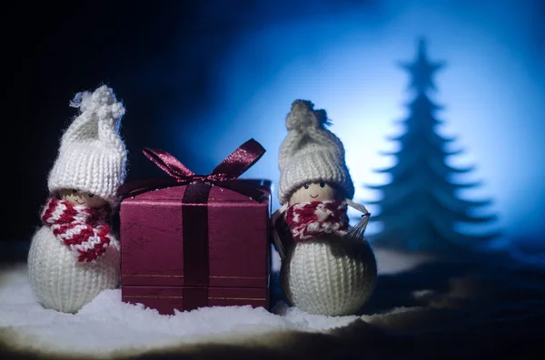 Feliz muñeco de Papá Noel en Navidad con árbol y nieve. Fondo bokeh colorido. Santa Claus y Feliz Navidad modelo figura juguete en tono oscuro — Foto de Stock