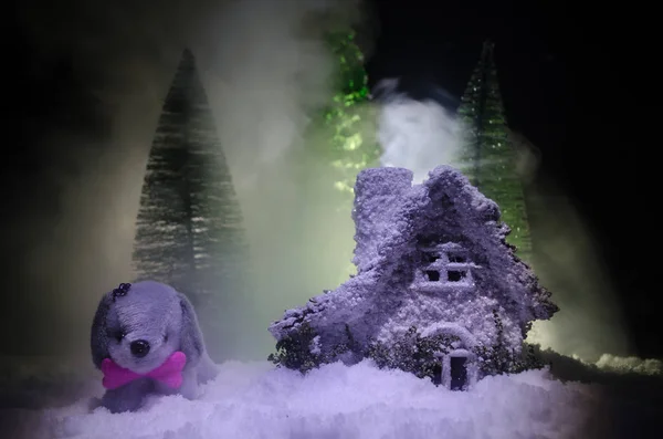 Chien jouet - symbole du Nouvel An sous la neige sur fond de branches de sapin. Chien de jouet comme symbole du Nouvel An 2018 avec un Noël attribue l'inscription du Nouvel An — Photo