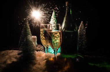 Flüt çifti ve şişe şampanya ile kar koyu arka plan üzerinde Noel ağacına yılbaşı kutlama arka plan.