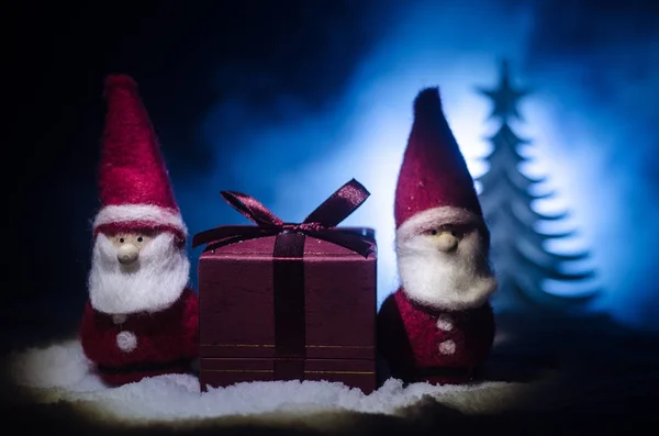 Happy Santa Claus Doll op Kersttijd met boom en sneeuw. Kleurrijke bokeh achtergrond. Kerstman en Merry Christmas model figuur speelgoed op donker getinte — Stockfoto