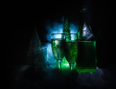 Flüt çifti ve şişe şampanya ile kar koyu arka plan üzerinde Noel ağacına yılbaşı kutlama arka plan.