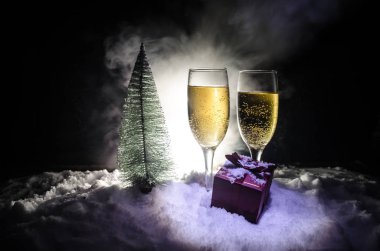 Flüt çifti ve şişe şampanya ile kar koyu arka plan üzerinde Noel ağacına yılbaşı kutlama arka plan.