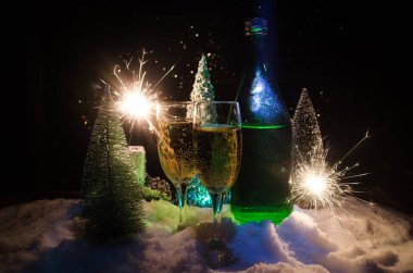 Flüt çifti ve şişe şampanya ile kar koyu arka plan üzerinde Noel ağacına yılbaşı kutlama arka plan.