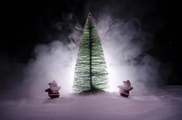 Счастливого Санта-Клауса на Рождество с елкой и снегом. Красочный боке фон. Санта-Клаус и весёлая рождественская игрушка в темном тонусе — стоковое фото