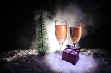 Flüt çifti ve şişe şampanya ile kar koyu arka plan üzerinde Noel ağacına yılbaşı kutlama arka plan.