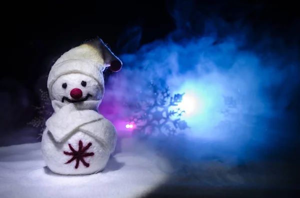 Neujahr. Der Schneemann lädt Geschenke für das neue Jahr aus. weißer Schneemann umgeben von Weihnachtsbäumen auf abendlichem Hintergrund. Spielzeugdekoration — Stockfoto