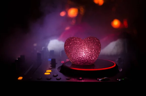 Mélangeur DJ avec écouteurs sur fond de boîte de nuit sombre avec sapin de Noël Nouvel An. Vue rapprochée des éléments ou symboles du Nouvel An (Santa Clause, Bonhomme de neige, Chien 2018, coffret cadeau) sur une table Dj. tonique — Photo