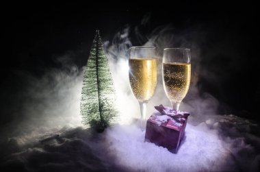 Flüt çifti ve şişe şampanya ile kar koyu arka plan üzerinde Noel ağacına yılbaşı kutlama arka plan.
