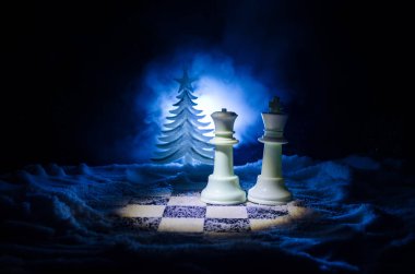Satranç karda. Kış konsepti. Noel ve yeni yıl bir satranç tahtası üzerinde mevcut karanlık bir arka plan üzerinde Noel Baba ile. Kopya alanı.