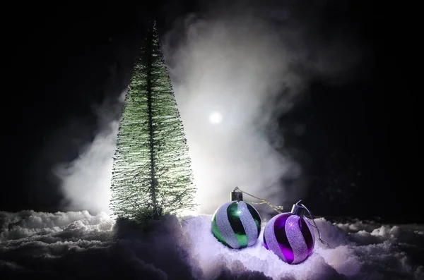 Χριστουγεννιάτικες μπάλες με το πεύκο στο χιόνι σε σκούρο φόντο. Γιορτή αντικείμενο με ελεύθερο χώρο για το κείμενο — Φωτογραφία Αρχείου